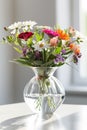 spring bouquet of beautiful flowers in a vase in the warm rays of the sun on the windowsill Royalty Free Stock Photo