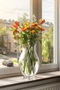 spring bouquet of beautiful flowers in a vase in the warm rays of the sun on the windowsill Royalty Free Stock Photo