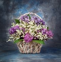 Spring bouquet. Lily of the valley and lilac in a basket Royalty Free Stock Photo