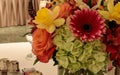 Spring bouquet of pink Gerbera daisies, yellow daffodils, orange roses, and green hydrangea