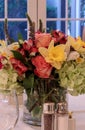 Spring bouquet of pink Gerbera daisies, yellow daffodils, orange roses, and green hydrangea