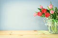 spring bouquet of red and pink tulips flowers in the glass vase over wooden table Royalty Free Stock Photo