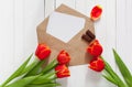 Spring bouquet of red tulips and a card in an envelope Royalty Free Stock Photo