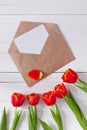 Spring bouquet of red tulips and a card in an envelope Royalty Free Stock Photo