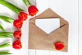 Spring bouquet of red tulips and a card in an envelope Royalty Free Stock Photo