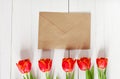 Spring bouquet of red tulips and a card in an envelope Royalty Free Stock Photo