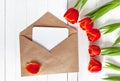 Spring bouquet of red tulips and a card in an envelope Royalty Free Stock Photo