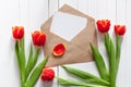 Spring bouquet of red tulips and a card in an envelope Royalty Free Stock Photo