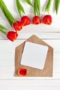 Spring bouquet of red tulips and a card in an envelope Royalty Free Stock Photo