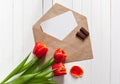 Spring bouquet of red tulips and a card in an envelope Royalty Free Stock Photo