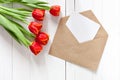 Spring bouquet of red tulips and a card in an envelope Royalty Free Stock Photo