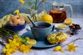 Spring breakfast. Appetizing donuts, cookies, a cup of herbal tea, lemons and yellow wild tulips on a rustic background Royalty Free Stock Photo