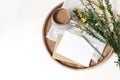 Spring breakfast scene. Yellow broom Cytisus branches, linen napkin, cup of coffee, wooden tray  on white table Royalty Free Stock Photo