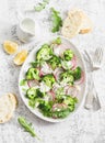 Spring broccoli and radish salad with yogurt sauce on a light background, top view. Delicious healthy vegetarian food Royalty Free Stock Photo