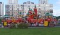 The playground with stairs, walkways and slides is located among residential buildings in an urban area.