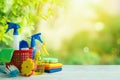 Spring cleaning concept with supplies on wooden table over beautiful green bokeh background Royalty Free Stock Photo