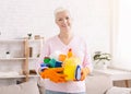 Smiling senior lady holding lots of detergents at home Royalty Free Stock Photo