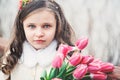 Spring close up portrait of child girl with tulips bouquet on the walk