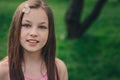 Spring closeup outdoor portrait of adorable 11 years old preteen kid girl