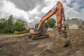 An orange tracked excavator at a construction site . Royalty Free Stock Photo