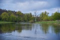Spring cloudy landscape. The river flows among the green banks. Royalty Free Stock Photo
