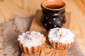 Spring composition chocolate muffins with raisins and hot tea in a clay cup. Sugar powder on the cakes. Morning sweet breakfast on