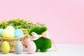 Spring composition. Easter eggs in a basket toy rabbit ears flowering branch on the table Royalty Free Stock Photo
