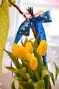 Spring composition: two easter whips with bunch of yellow tulips