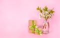 Spring composition, white cherry flowers. Gift boxes on pink background.