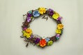 Spring composition of a wreath of birch branches and craft colorful flowers