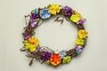 Spring composition of a wreath of birch branches and craft colorful flowers