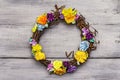 Spring composition of a wreath of birch branches and craft colorful flowers