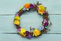 Spring composition of a wreath of birch branches and craft colorful flowers