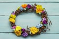 Spring composition of a wreath of birch branches and craft colorful flowers