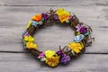 Spring composition of a wreath of birch branches and craft colorful flowers