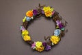 Spring composition of a wreath of birch branches and craft colorful flowers