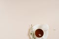 Spring concept. Cup of morning black tea with sweets marshmallows on beige background with sprig of blooming apple tree with copy