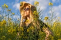 Spring concept.Woman in straw sun hat enjoys a summer walk in yellow flowers field