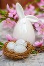 Spring conceptual photo with flowers. Flat lay blooming tree, easter eggs. The tree blooms pink and the eggs in the nest and copy