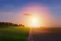 Spring countryside landscape; sunrise over spring farmland field and country road Royalty Free Stock Photo