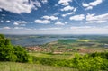 Spring countryside with village, lake, blue sky and clouds