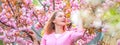 Spring couple in love, banner. Blonde woman enjoying a moment in blossoming sakura garden. Sunny spring day. Happy girl