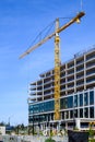 Spring District, under construction, crane loading in new window to workers ready to install