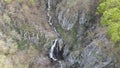 Spring drones over a waterfall at Boyana Waterfall in Vitosha mountain at Bulgaria. Aerial footage of a forest with pines and wate