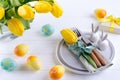 Spring Easter background for menu. Easter egg decoration, bunny, linen napkin on plate and kitchen cutlery on white table Royalty Free Stock Photo