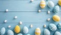 Spring Easter composition of painted pastel easter eggs with white decorations on light blue wooden table top view. Greeting card