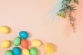 Spring Easter layout made with colorful eggs and green plants with flowers on a pastel pink background. Minimal flat lay Royalty Free Stock Photo