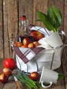 Spring Easter picnic background. Food basket with a bottle of homemade wine and Easter cakes with eggs on a wooden rustic table