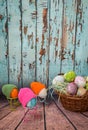 spring easter still life, easter eggs with bird paws and in colorful knitted hats look at easter eggs in a basket