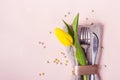 Spring Easter table setting. Cutlery is decorated with beautiful yellow tulip close-up Royalty Free Stock Photo